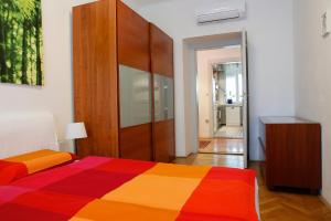 1 dormitorio con 1 cama colorida y armario de madera en Tomas's apartment, en Liubliana