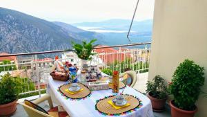 una mesa en un balcón con vistas a las montañas en Delphic Horizons en Delfoi
