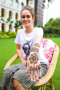 a woman sitting in a chair with henna on her hands at The Grand Imperial - Heritage Hotel in Agra