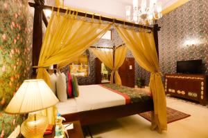 a bedroom with a canopy bed and a television at The Grand Imperial - Heritage Hotel in Agra