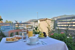 a table with breakfast food and drinks on a balcony at New Ca'Mea in Villasimius