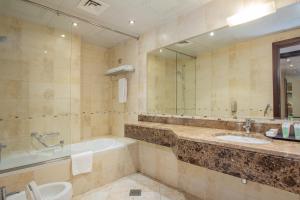 a bathroom with a tub and a sink and a bath tub at City Premiere Hotel Apartments - Dubai in Dubai