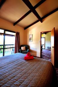 a bedroom with a bed with a red towel on it at Greenacres Alpine Chalets & Villas in Hanmer Springs