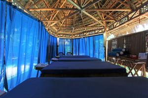 a row of beds in a room with blue drapes at Thalatta Resort in Zamboanguita