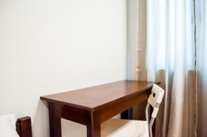 a wooden table with a chair next to a window at Seasons Hotel Sablayan in Buenavista