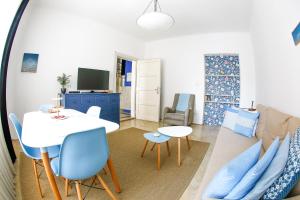sala de estar con mesa blanca y sillas azules en Taya apartment, en Liubliana