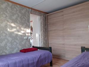 a bedroom with two beds and a wall with wood at Comfort flat & parking Gertrudes Street Riga in Riga