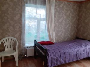 a bedroom with a purple bed and a chair and a window at Comfort flat & parking Gertrudes Street Riga in Riga