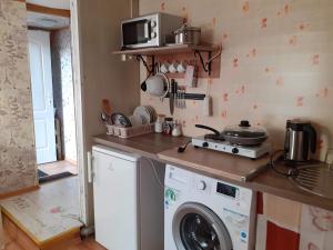 a kitchen with a washing machine and a microwave at Comfort flat & parking Gertrudes Street Riga in Riga