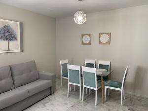 ein Wohnzimmer mit einem Sofa, einem Tisch und Stühlen in der Unterkunft Apartment Lucena Center Bajo in Lucena