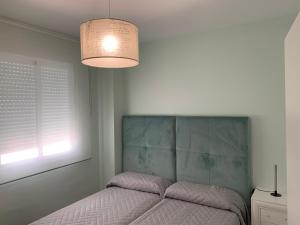 a bedroom with a bed and a light fixture at Apartment Lucena Center Bajo in Lucena