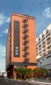 un bâtiment avec un panneau sur son côté dans l'établissement Just Sleep - Sanchong, à Taipei