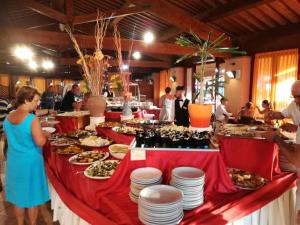 プントーネ・ディ・スカルリーノにあるResidence I Tusciの食べ物と人の皿が並ぶビュッフェ式テーブル