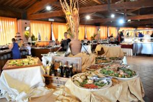 una línea de buffet con platos de comida en las mesas en Residence I Tusci, en Puntone di Scarlino