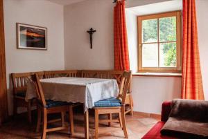 una sala da pranzo con tavolo, sedie e finestra di Paulnhof a Brennero