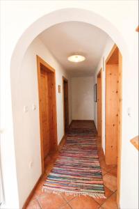 a hallway with an archway and a rug at Paulnhof in Brennero