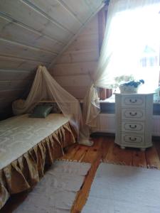 a bedroom with a bed and a dresser and a window at Chata Magnata in Zamość