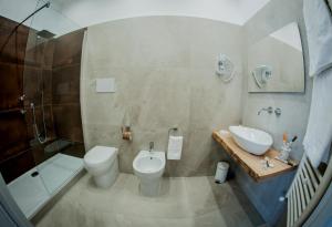 a bathroom with a toilet and a sink and a shower at B&B iMori in Caltagirone