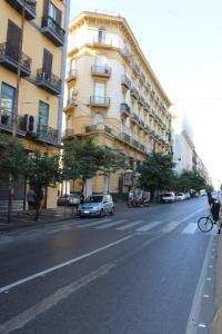 Eine Person, die mit dem Fahrrad eine Straße entlang fährt, neben einem Gebäude in der Unterkunft Residenza La Scala in Neapel