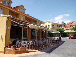 a restaurant with tables and chairs outside of a building at A Fontiña in Montalvo