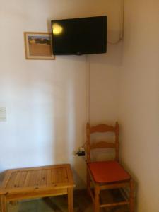 スカラ・カロニスにあるMaria's Studiosの椅子と壁掛けテレビ付きの客室です。