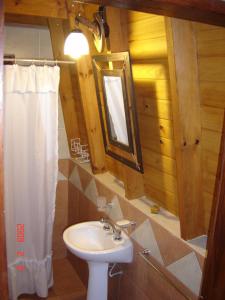baño con lavabo y cortina de ducha blanca en Cabañas Ecos del Rio en Los Reartes