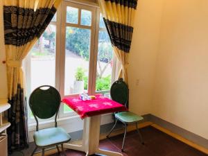 a table and two chairs in a room with a window at Khách sạn Hương Mê in Buon Ma Thuot
