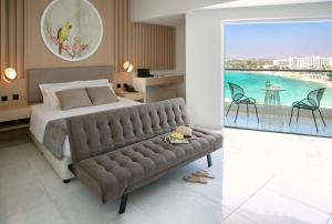 a bedroom with a large bed and a couch at NissiBlu Beach Resort in Ayia Napa