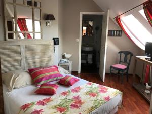 a bedroom with a bed with two pillows on it at Hotel Logis Beauséjour in Erquy