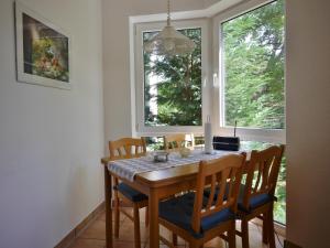 einen Esstisch mit Stühlen und ein Fenster in der Unterkunft Fewo D am Kurpark in Willingen