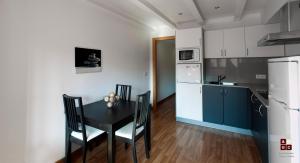 a kitchen with a black table and chairs in a room at Apartaments Girona Centre in Girona