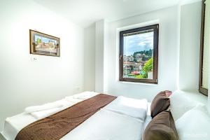 une chambre blanche avec un lit et une fenêtre dans l'établissement Urania Apartments, à Ohrid