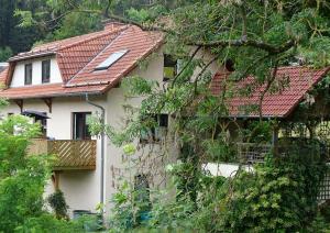 a white house with a red roof at Ferienwohnung am Berggrabenweg in Ilmenau