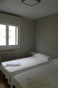 a bedroom with two beds and a window at Pension Obel in Villava