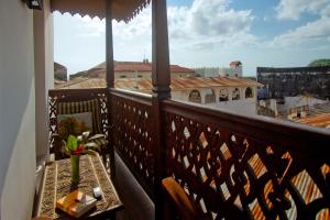 a balcony with a table and a view of a city at Asmini Palace Hotel in Zanzibar City