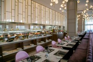 a restaurant with tables and pink chairs and a buffet at NissiBlu Beach Resort in Ayia Napa