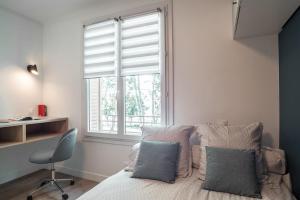 - une chambre avec un lit, une fenêtre et une chaise dans l'établissement Le joyau de Belledonne, à Chambéry