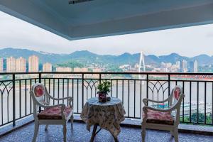 a balcony with a table and chairs and a view of the city at Chongqing King's Landing RiverView BnB in Chongqing