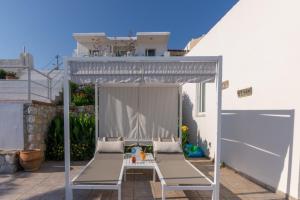 a white bed sitting under an umbrella in front of a building at Frida Apartments in Chania