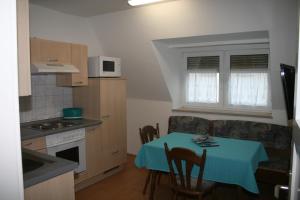 a small kitchen with a table with a blue table cloth at Ferienwohnung Franken in Fürth