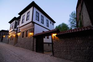 un edificio en una calle junto a una pared de piedra en Mehves Hanim Konagi, en Safranbolu