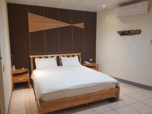 1 dormitorio con 1 cama grande con sábanas blancas en Matsu B&B en Nangan
