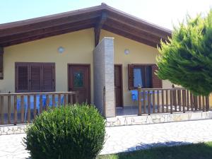 uma pequena casa com um alpendre e uma varanda em Resort Te Zagolli em Orikum