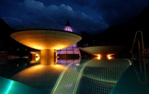una gran piscina con 2 grandes luces por la noche en Gästehaus Riml en Längenfeld