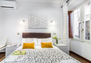 1 dormitorio con 1 cama grande con almohadas amarillas en Sant'Angelo Apartments, en Roma