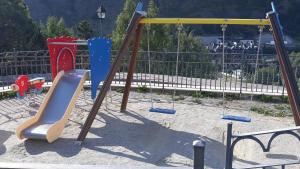 a playground with a slide in a park at SOLDEU cosy home in Soldeu
