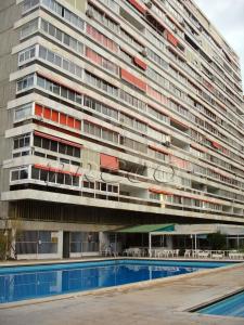 a large building with a swimming pool in front of it at Apartamentos Cervantes in Benidorm