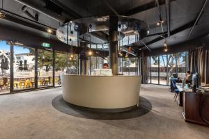 a lobby with a reception desk in a building with windows at Melbourne Holiday Apartments Flinders Wharf in Melbourne