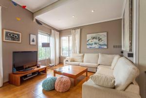 un salon avec un canapé et une télévision dans l'établissement La Casa del Río, à Pedralba