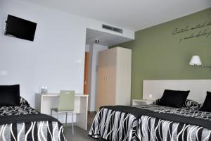 Televízia a/alebo spoločenská miestnosť v ubytovaní Hotel HM Alfaro
